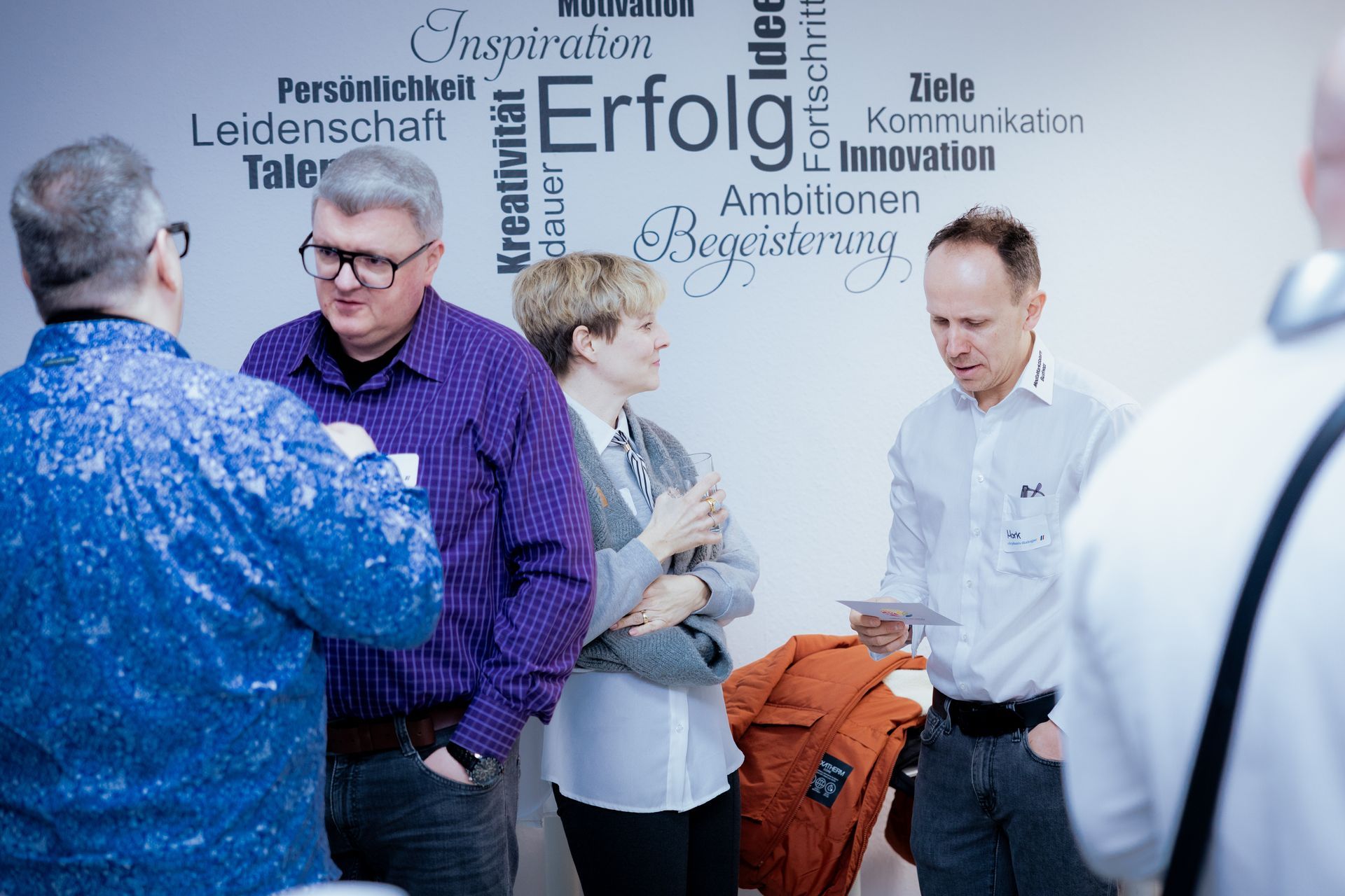 Eine Person, die nachts mit einem Golfschläger spielt, eine Weihnachtsmannmütze trägt und auf einer grünen Matte steht.