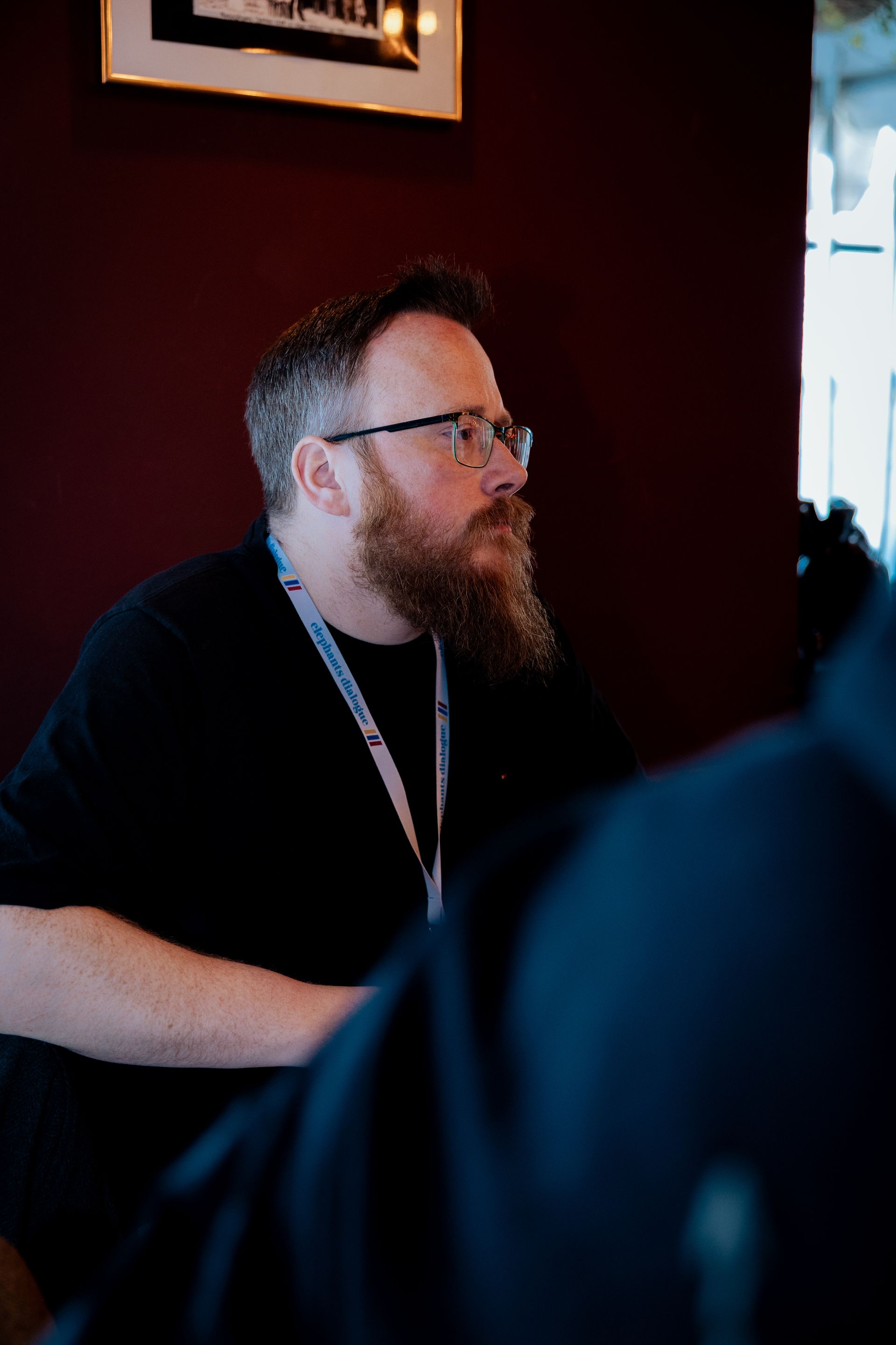 Eine Person, die nachts mit einem Golfschläger spielt, eine Weihnachtsmannmütze trägt und auf einer grünen Matte steht.