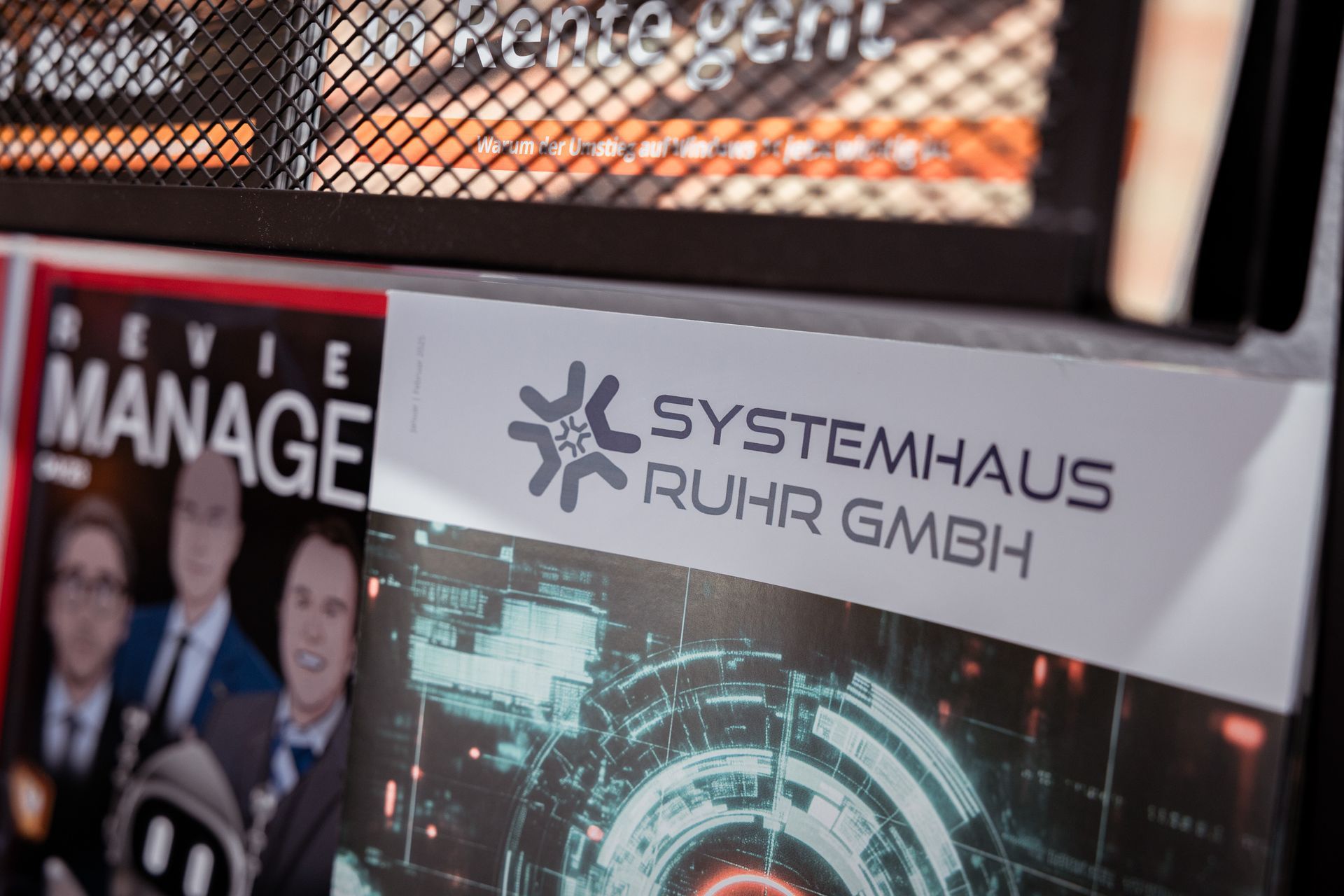 Broschüre mit dem Logo der Systemhaus Ruhr GmbH in einem Zeitschriftenständer.