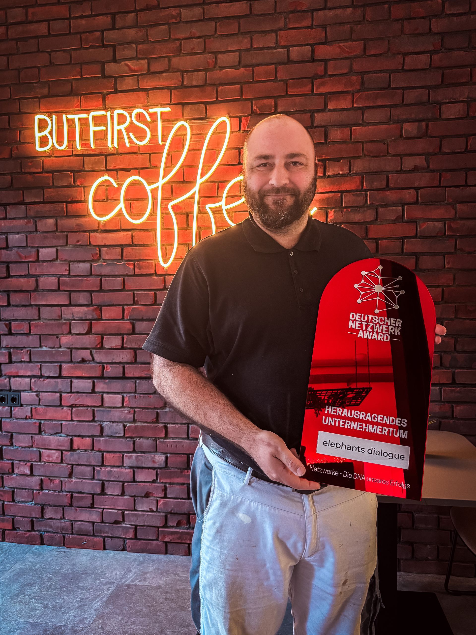 Eine Person, die nachts mit einem Golfschläger spielt, eine Weihnachtsmannmütze trägt und auf einer grünen Matte steht.