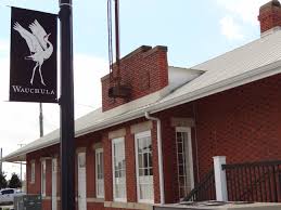 Wauchula train depot with a brick exterior and a banner featuring a white bird silhouette.