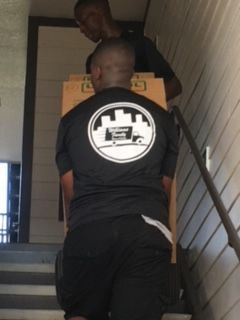 Two men are carrying boxes up a set of stairs