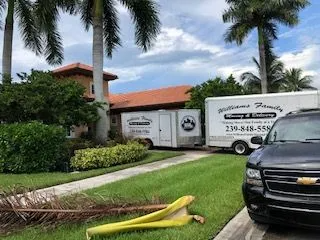 A truck and trailer are parked in front of a house.