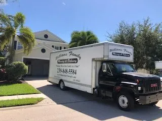 A moving truck is parked in front of a house.