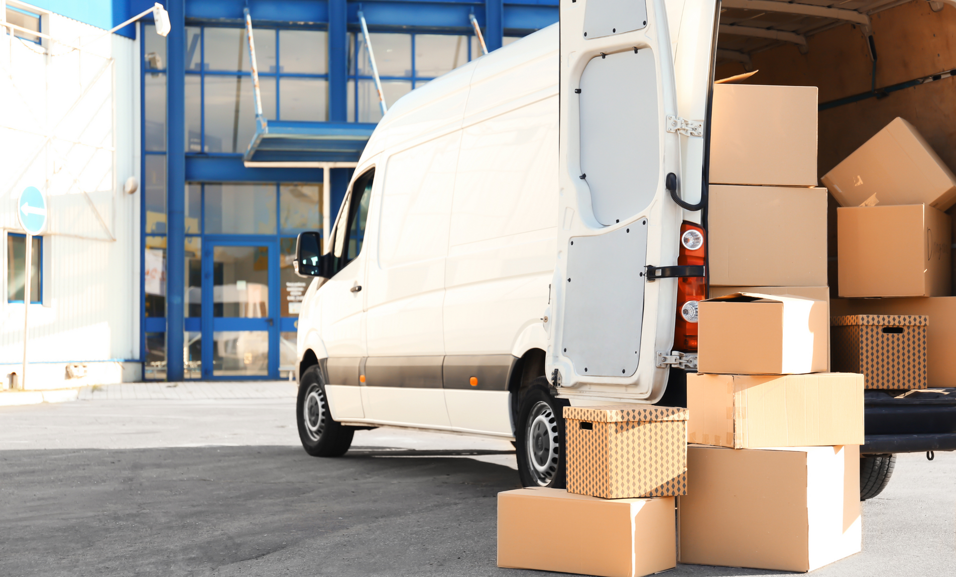 Two movers are carrying boxes out of a van.