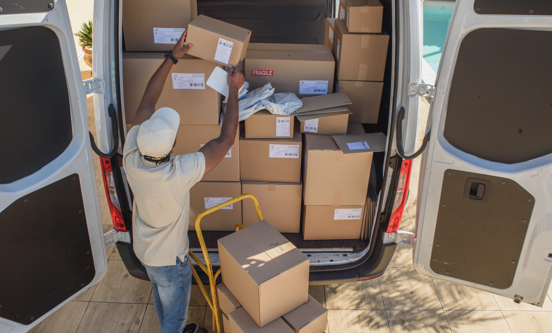Two movers are carrying boxes out of a van.
