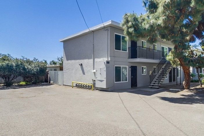 A small apartment building with stairs leading up to the second floor.