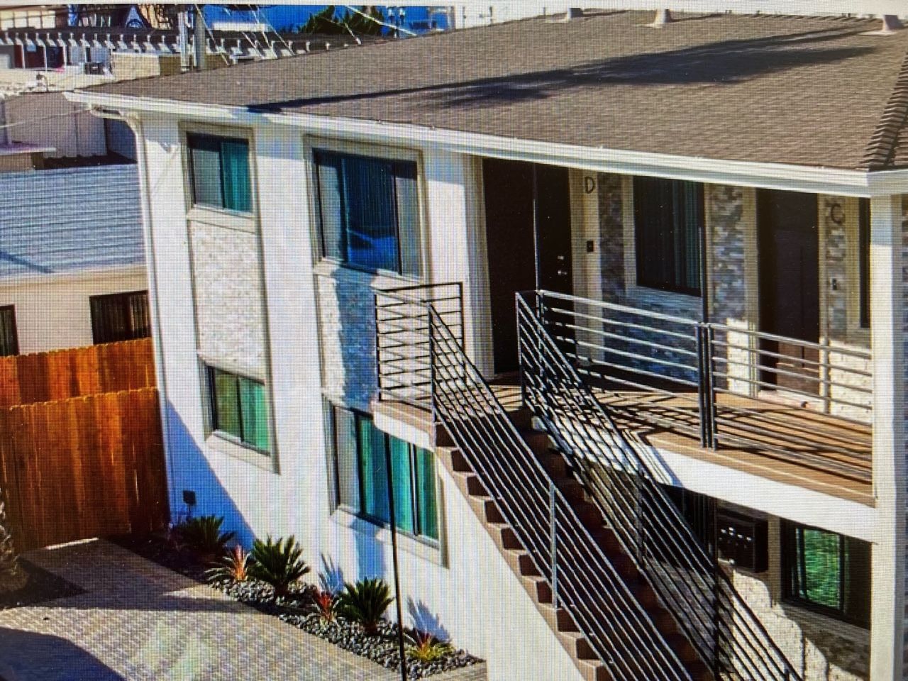 A white apartment building with stairs leading up to the second floor