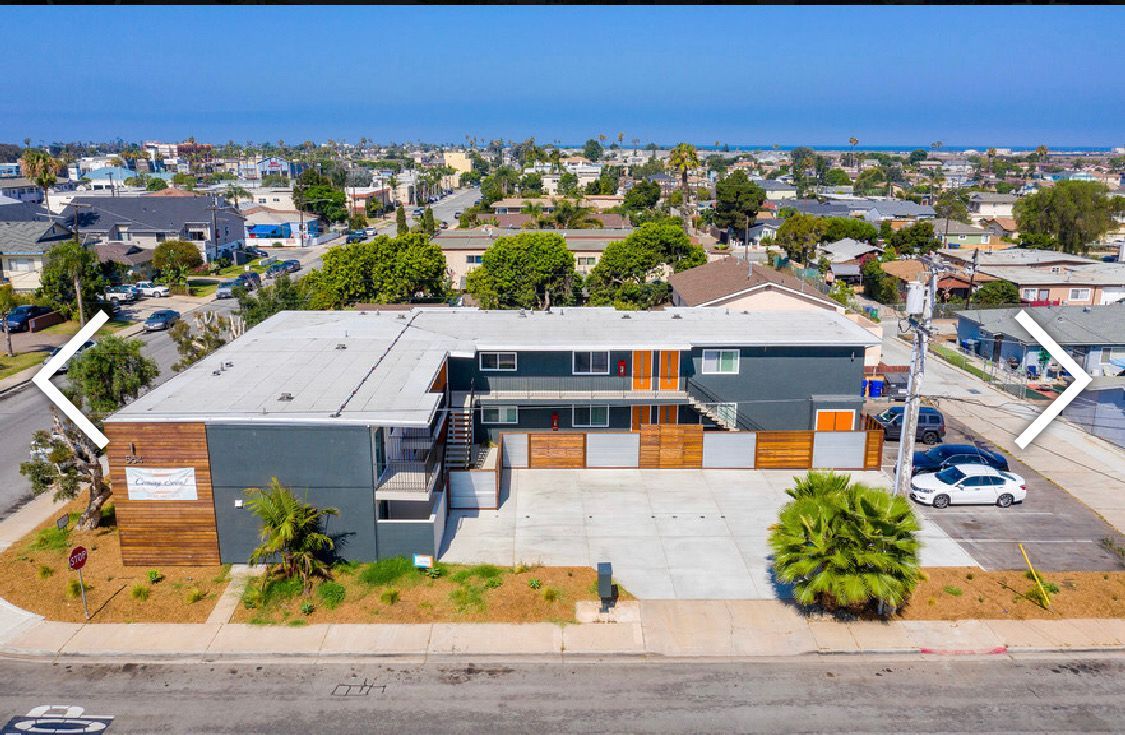An aerial view of a building with cars parked in front of it.
