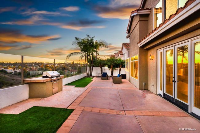 A large house with a patio with a grill and sliding glass doors
