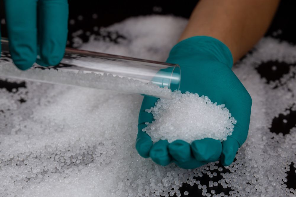 a scientist holding little bits of bio-based synthetic rubbers