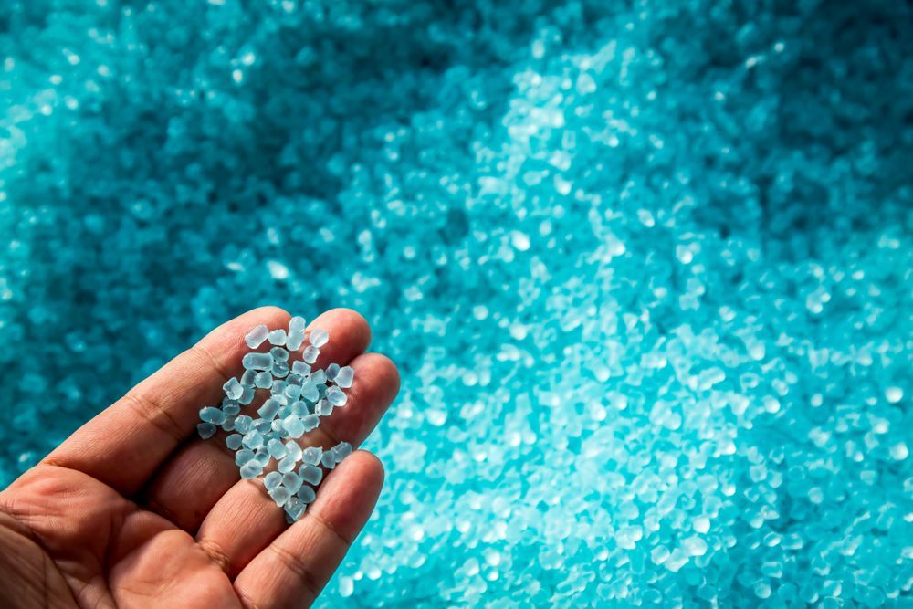 hand holding pieces of petroleum-based plastics