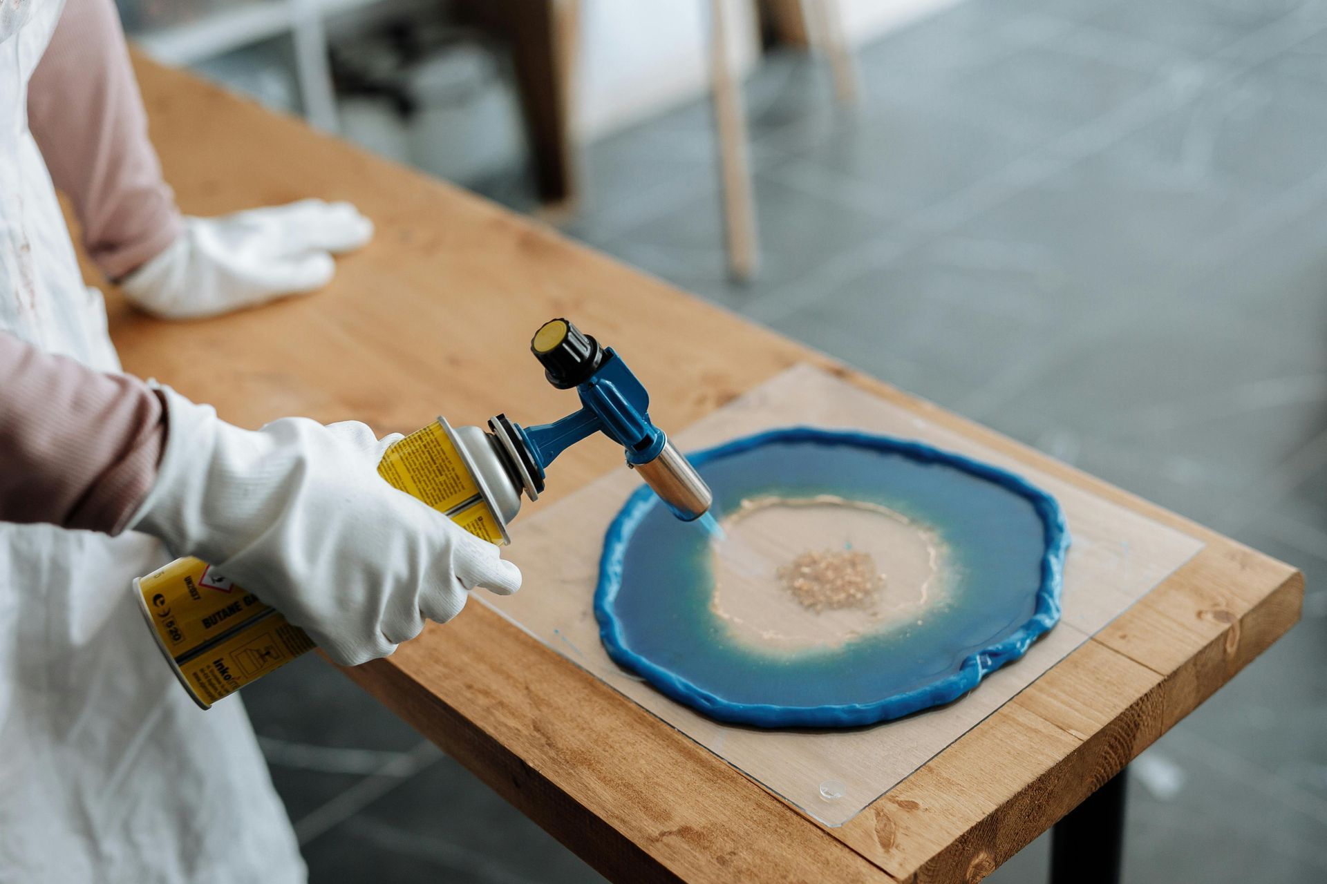 Hand holding blow torch to melt epoxy.