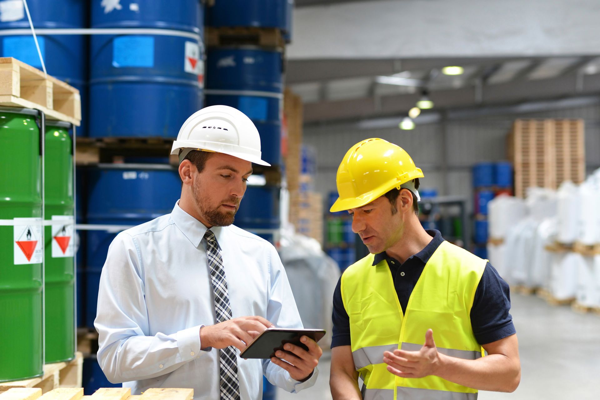 a specialty chemical supplier speaks with a foreman in the logistics industry work in a warehouse with chemicals | they rely on a specialty chemical supplier