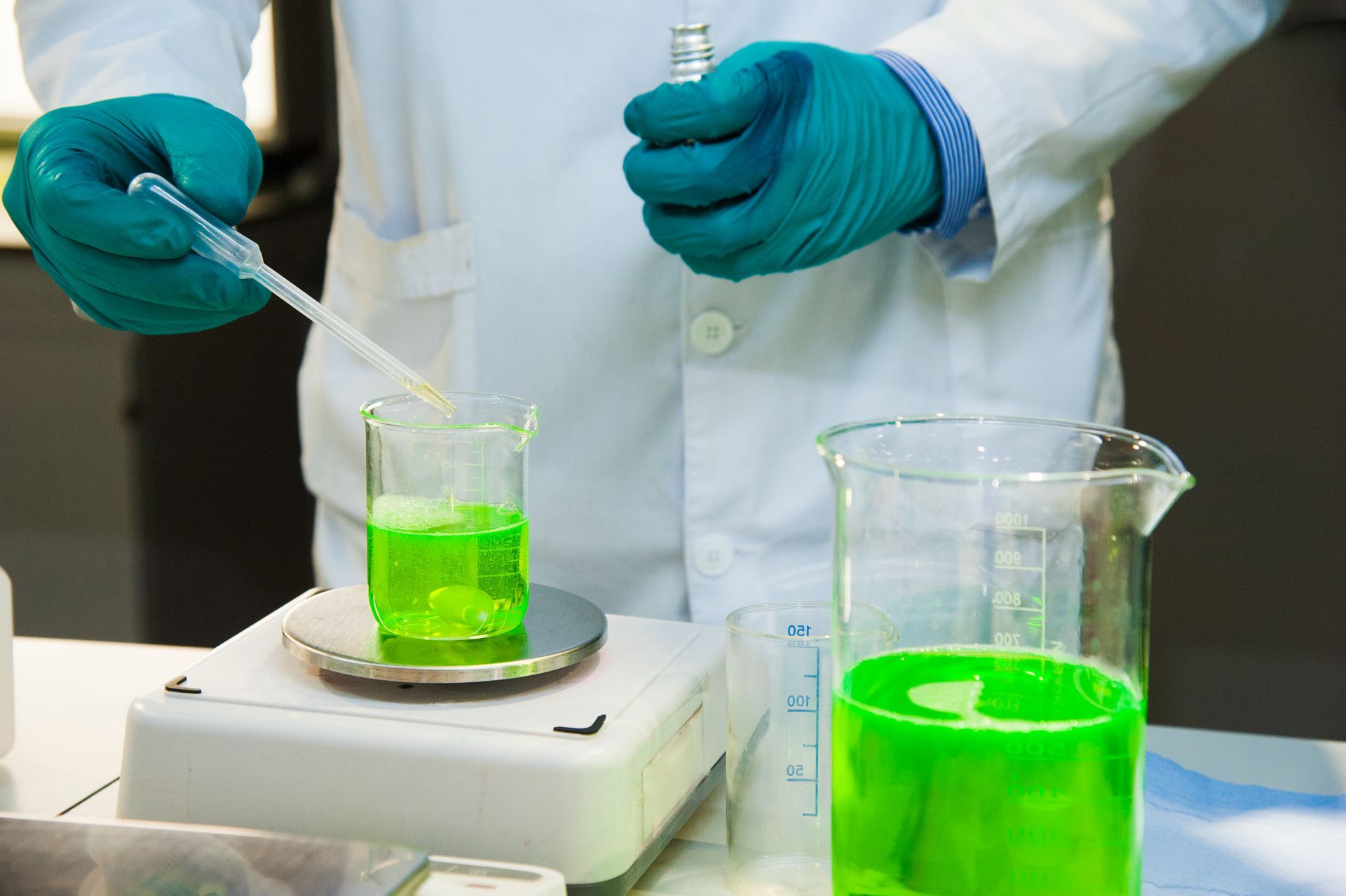 a scientist is pouring an industrial solvent into a beaker