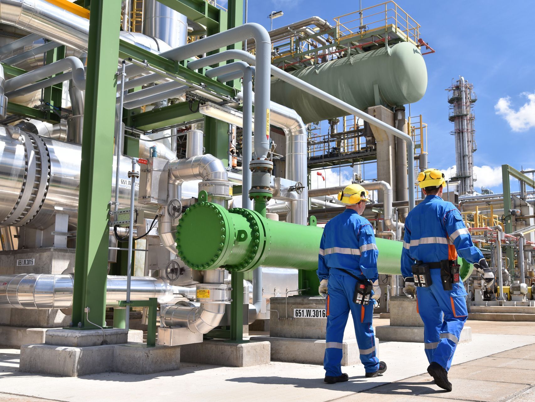 chemical insdustry plant workers walking around a refinery producing green solvents