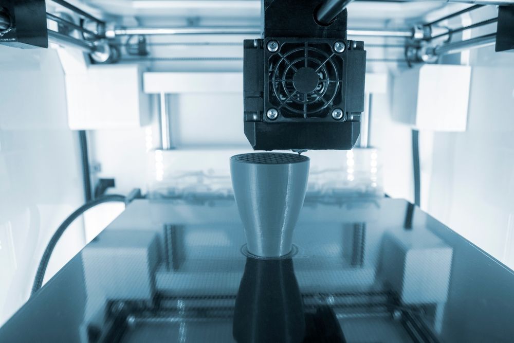 A close up of a 3d printer printing a metal object.