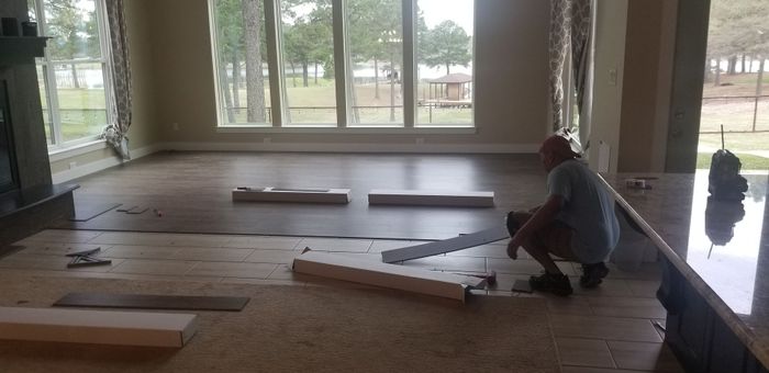 a man is installing a wooden floor in a living room