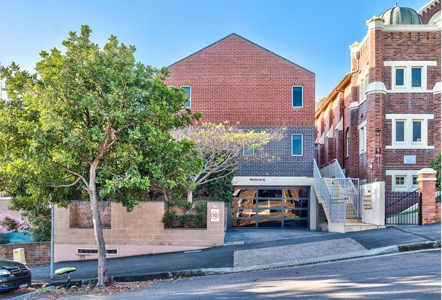 A Large Brick Building with Stairs Leading up To It — Maison Property Management in Mayfield, NSW