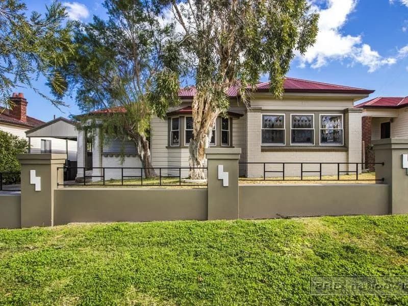 A House with A Fence and A Tree in Front of It — Maison Property Management in New Lambton, NSW