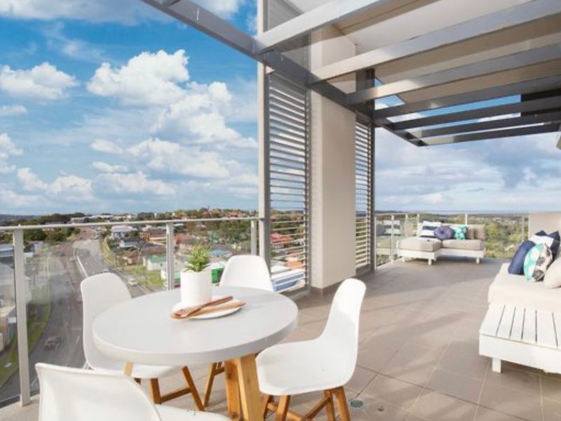 A Balcony with A Table and Chairs and A View of The City — Maison Property Management in Mayfield, NSW