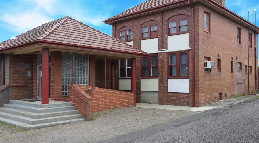 A large brick building with stairs leading up to it — Maison Property Management in Mayfield, NSW