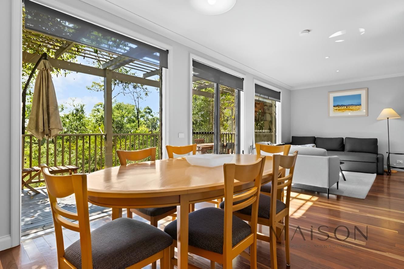 Living Room With a Table and Chairs and a Balcony — Maison Property Management in Pokolbin, NSW