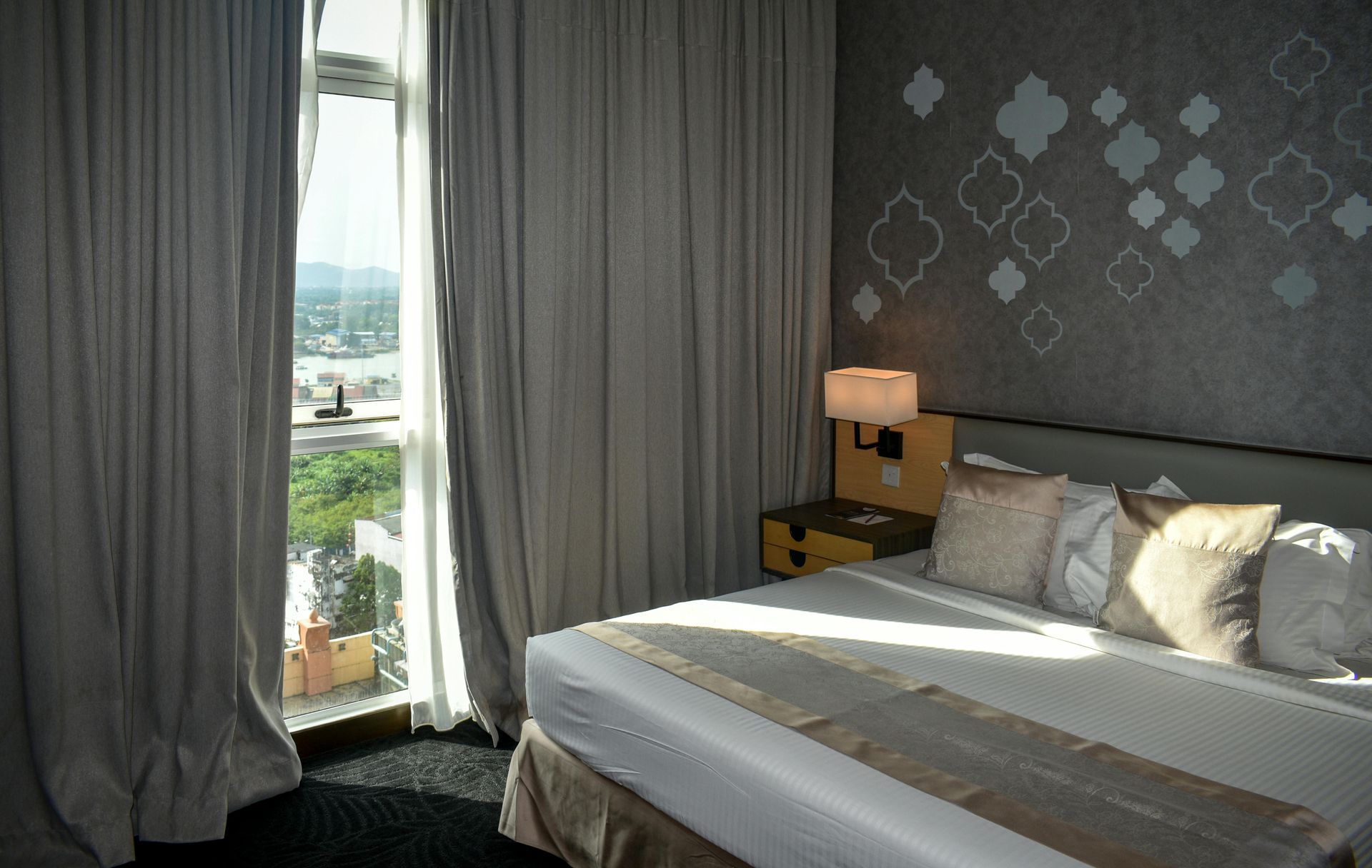 A Family Is Standing in A Hotel Room Looking at A Bed — Maison Property Management in Mayfield, NSW