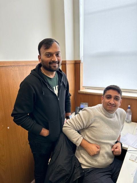 Two Men Standing Next to Each Other in a Room