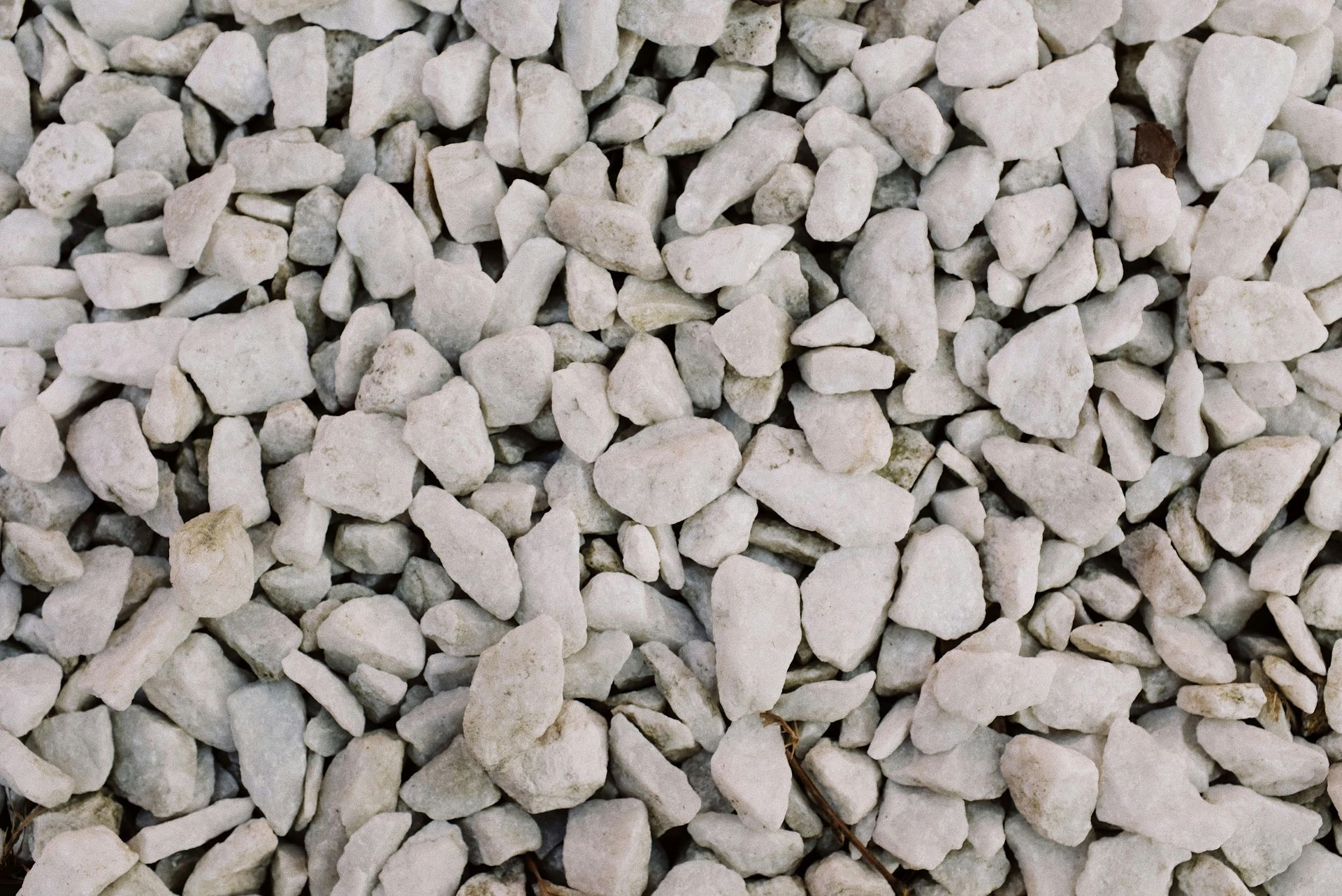 Close-up of a pile of small, irregularly shaped, light-colored gravel.