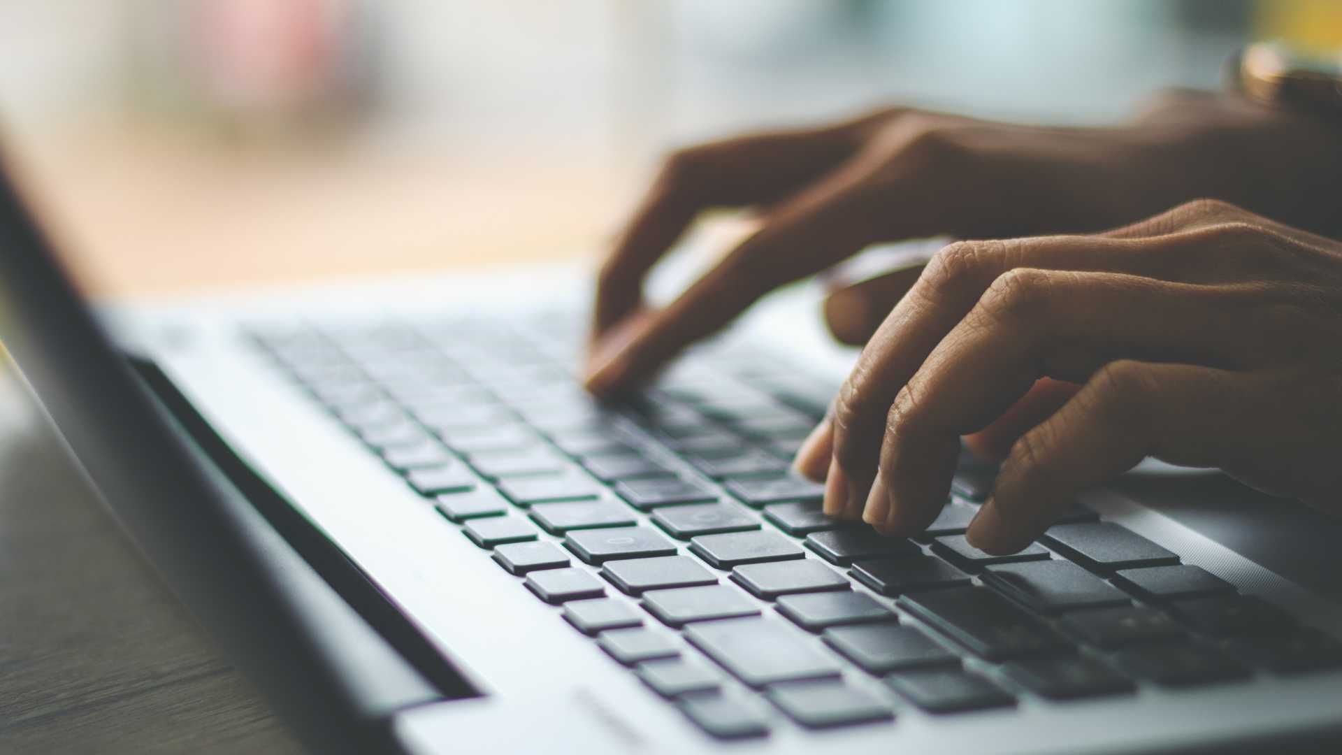 A person is typing on a laptop computer.
