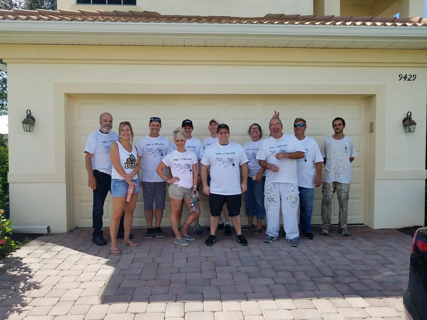 A group of people are posing for a picture in front of a house.