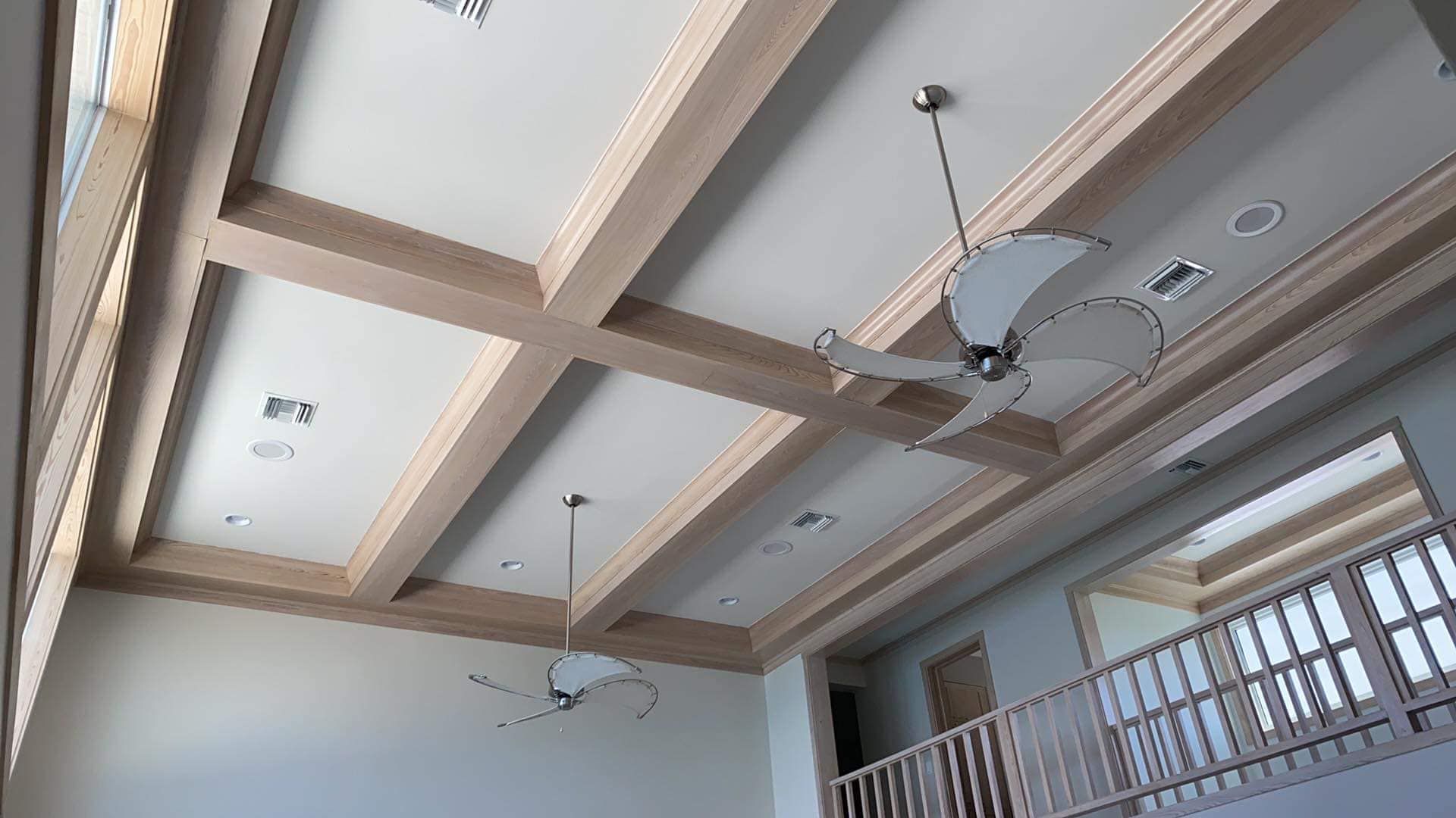 A ceiling fan is hanging from the ceiling of a room with a balcony.