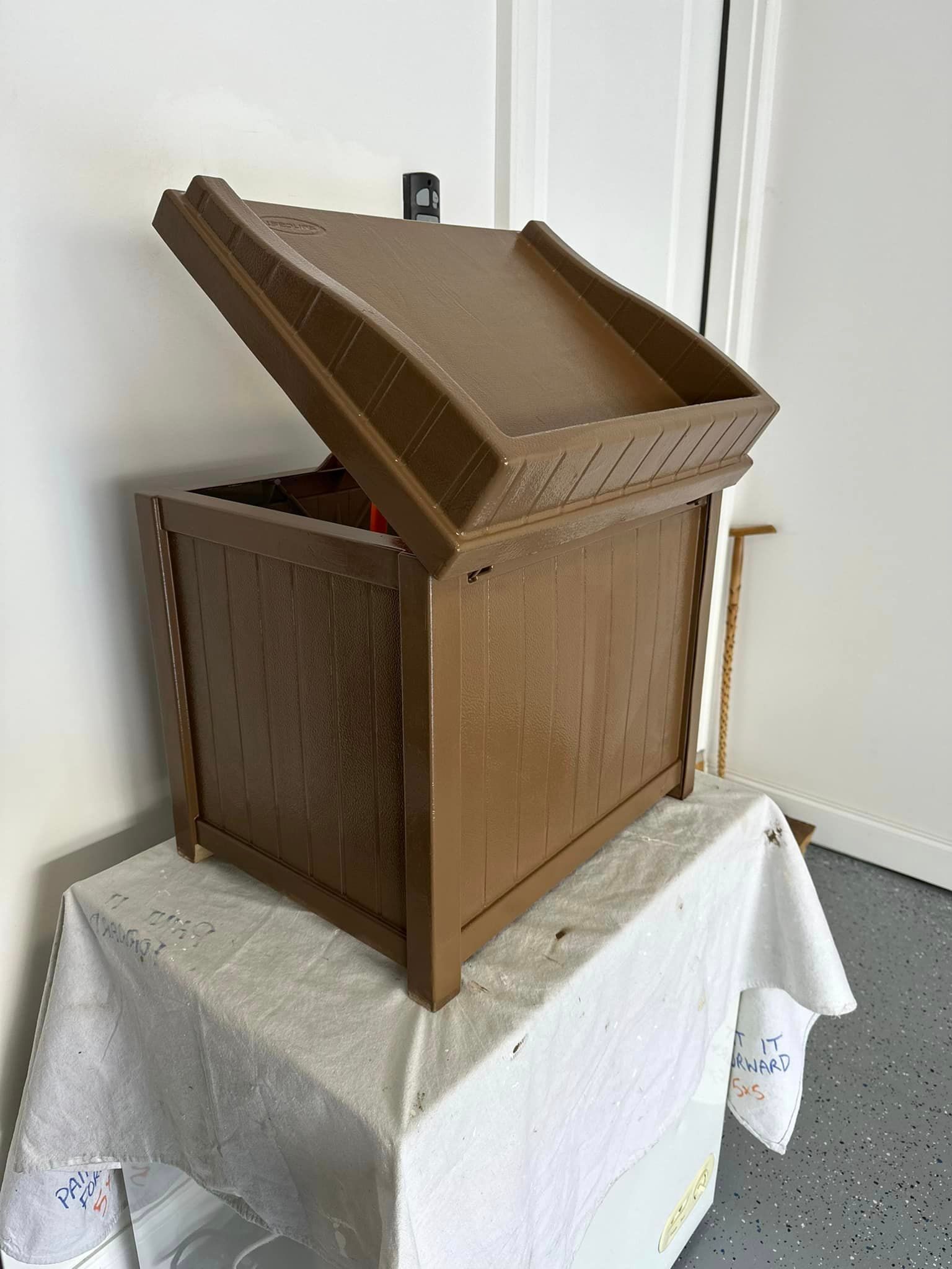 A wooden box with the lid open is sitting on a table.