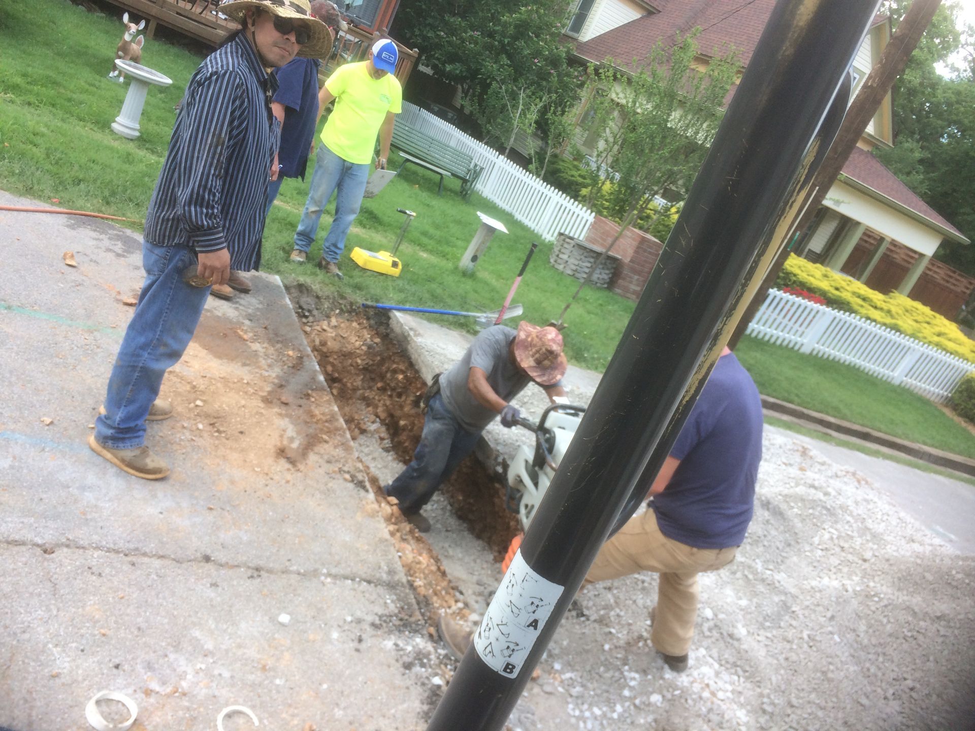 A group of men are working on a sidewalk.