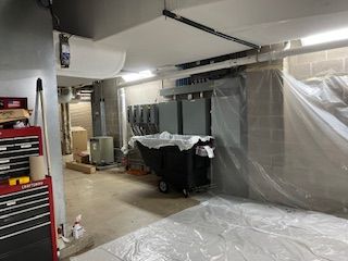 There is a trash can in the middle of the room covered in plastic.