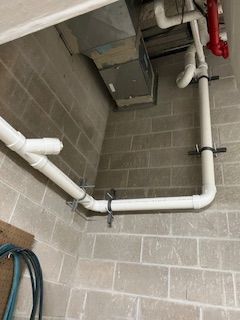 There are a lot of pipes hanging from the ceiling in a room.