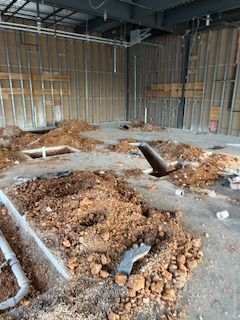 A building under construction with a lot of dirt on the floor.