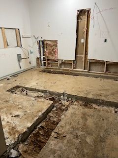 A room with a hole in the floor and a hole in the wall.