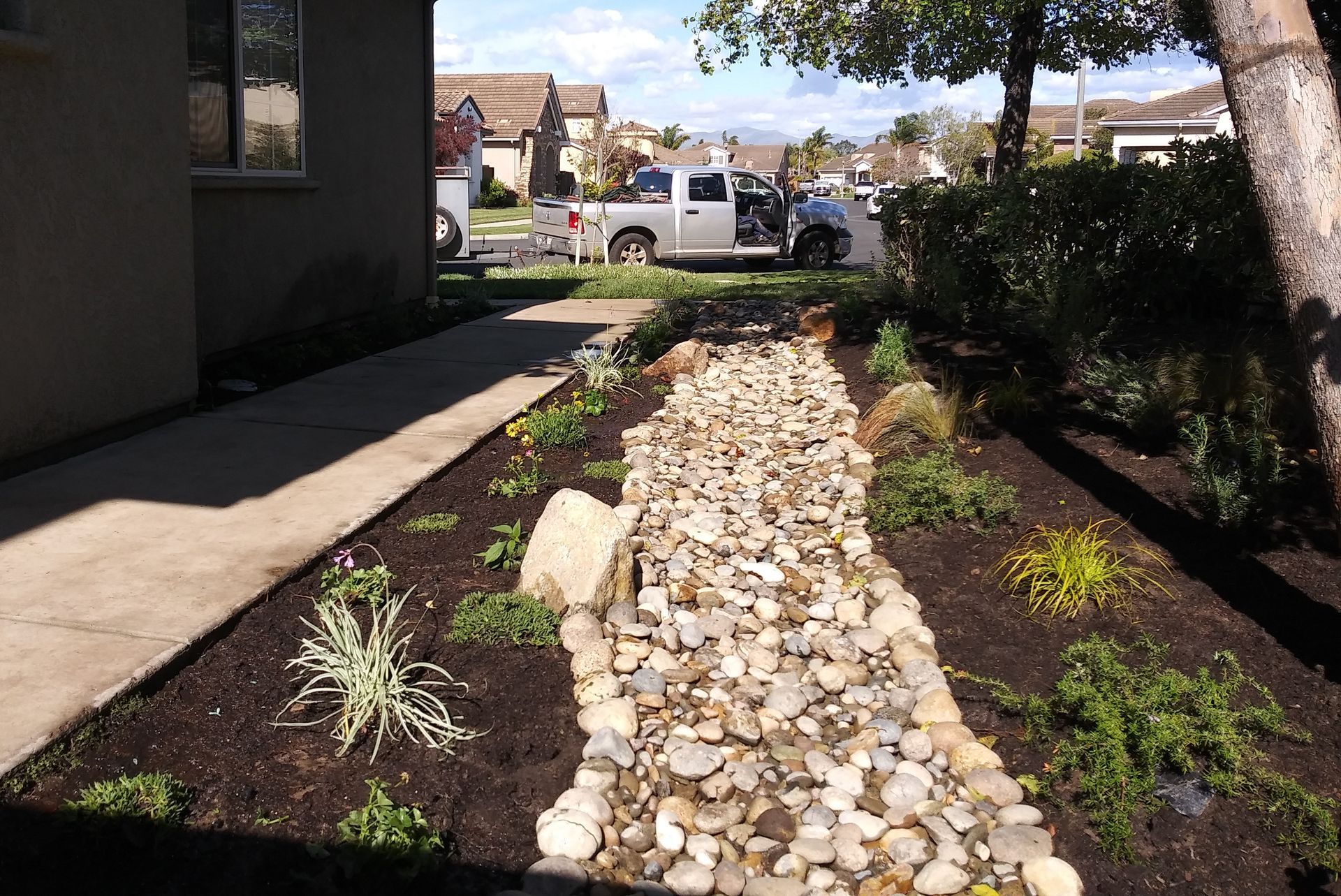 A white truck is parked in the driveway of a house