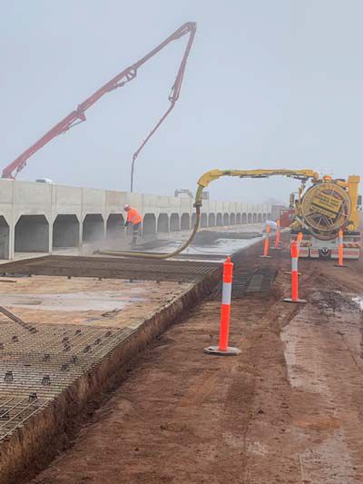 A concrete pump is being used to pour concrete on a bridge.