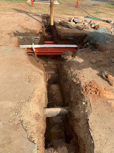 A large hole in the ground with a pipe in it.