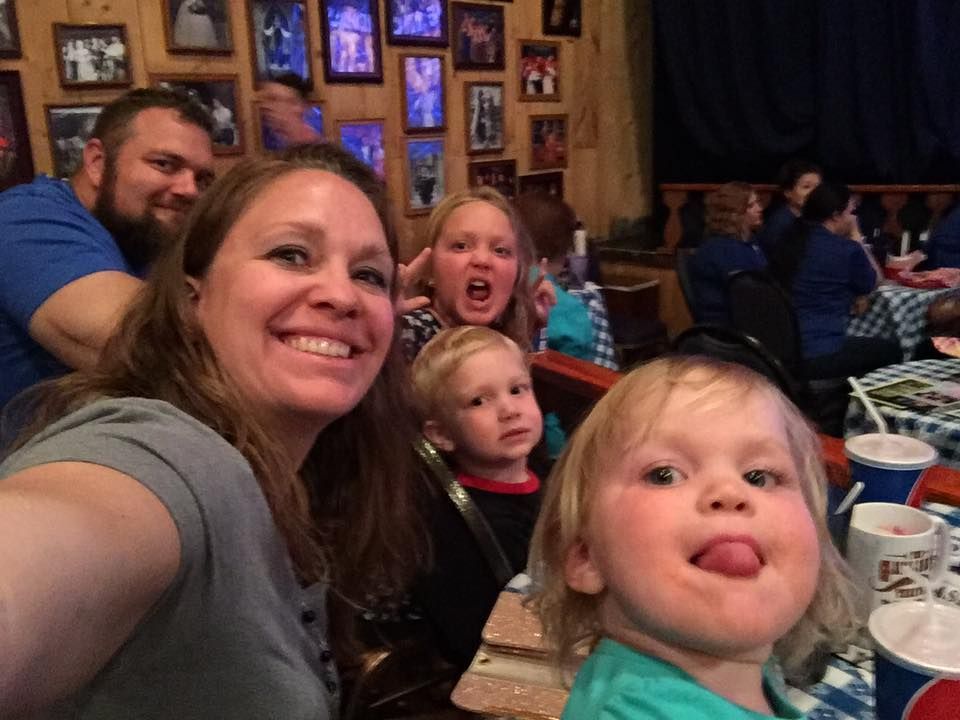 Christopher Patterson and family posing for a picture in a restaurant.