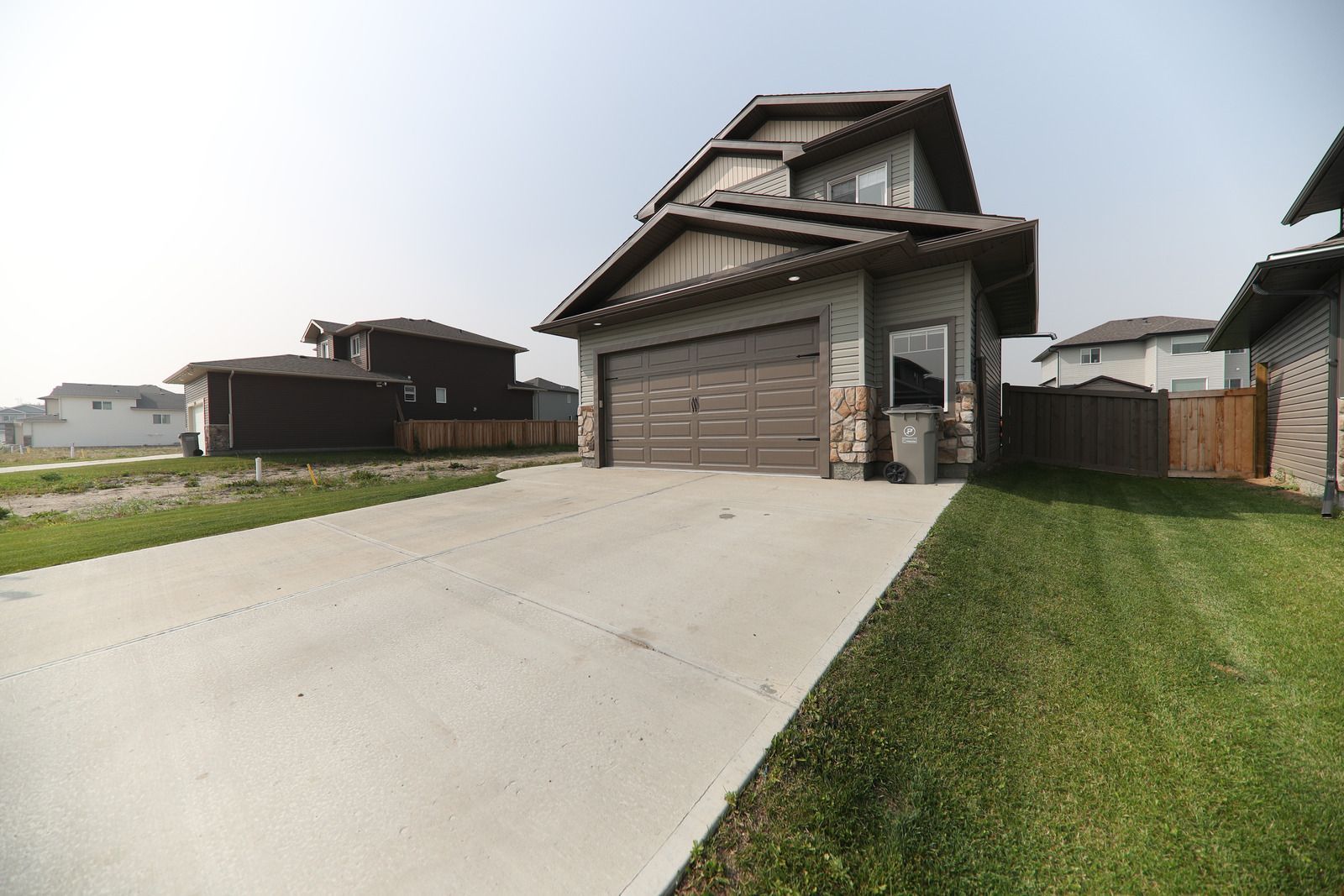 Construction site with concrete foundation and steps, surrounded by sand and brick, in a wooded area.