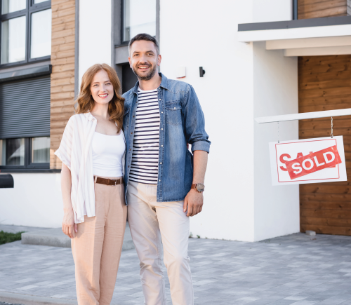 Couple standing in front of a house with a