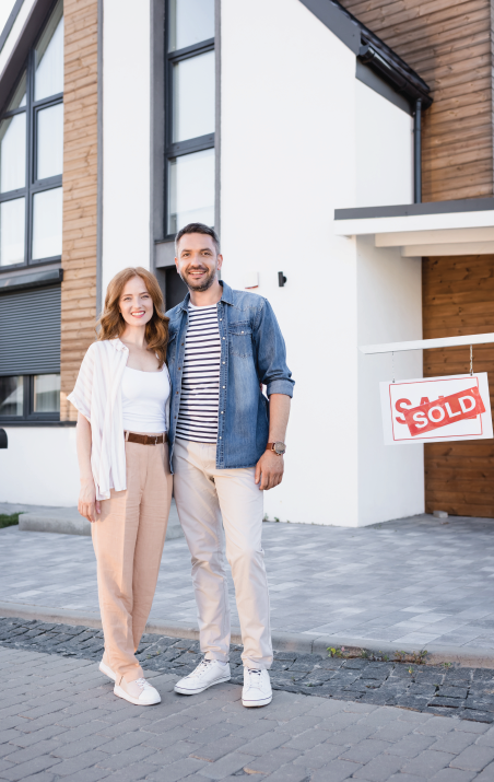 Couple standing in front of a house with a