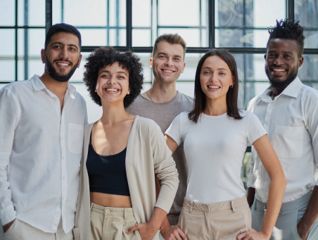 Smiling diverse group of business professionals in an office hallway.