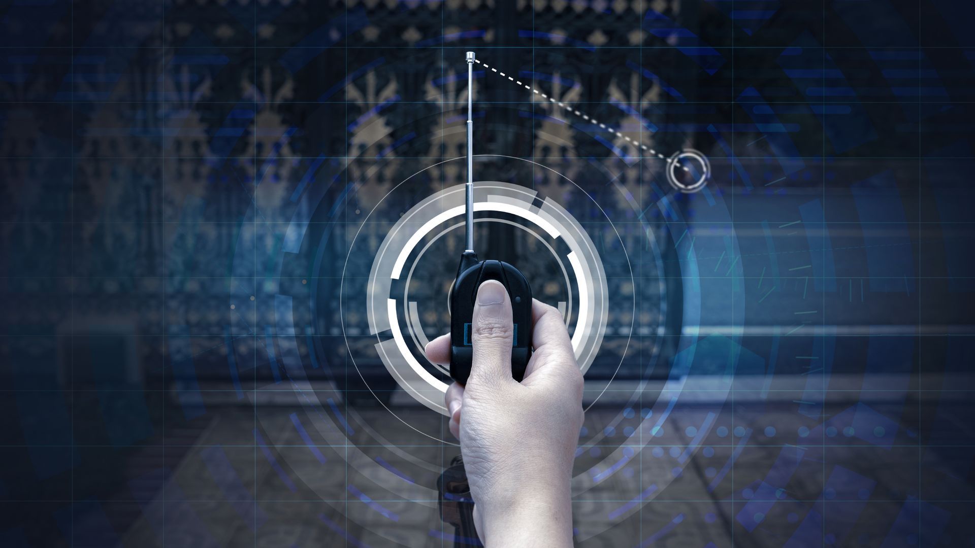 A person's hand holding an autogate remote with a telescopic antenna, featuring futuristic digital s