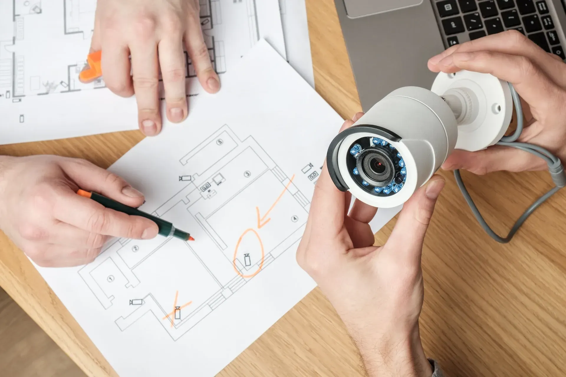Planning security camera placement on a property blueprint during an alarm system installation.