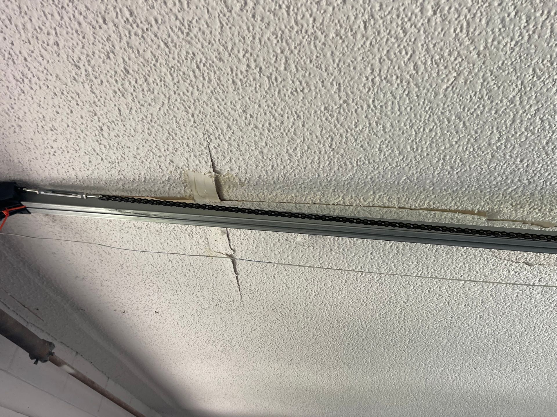 A close up of a ceiling with a metal bar hanging from it.